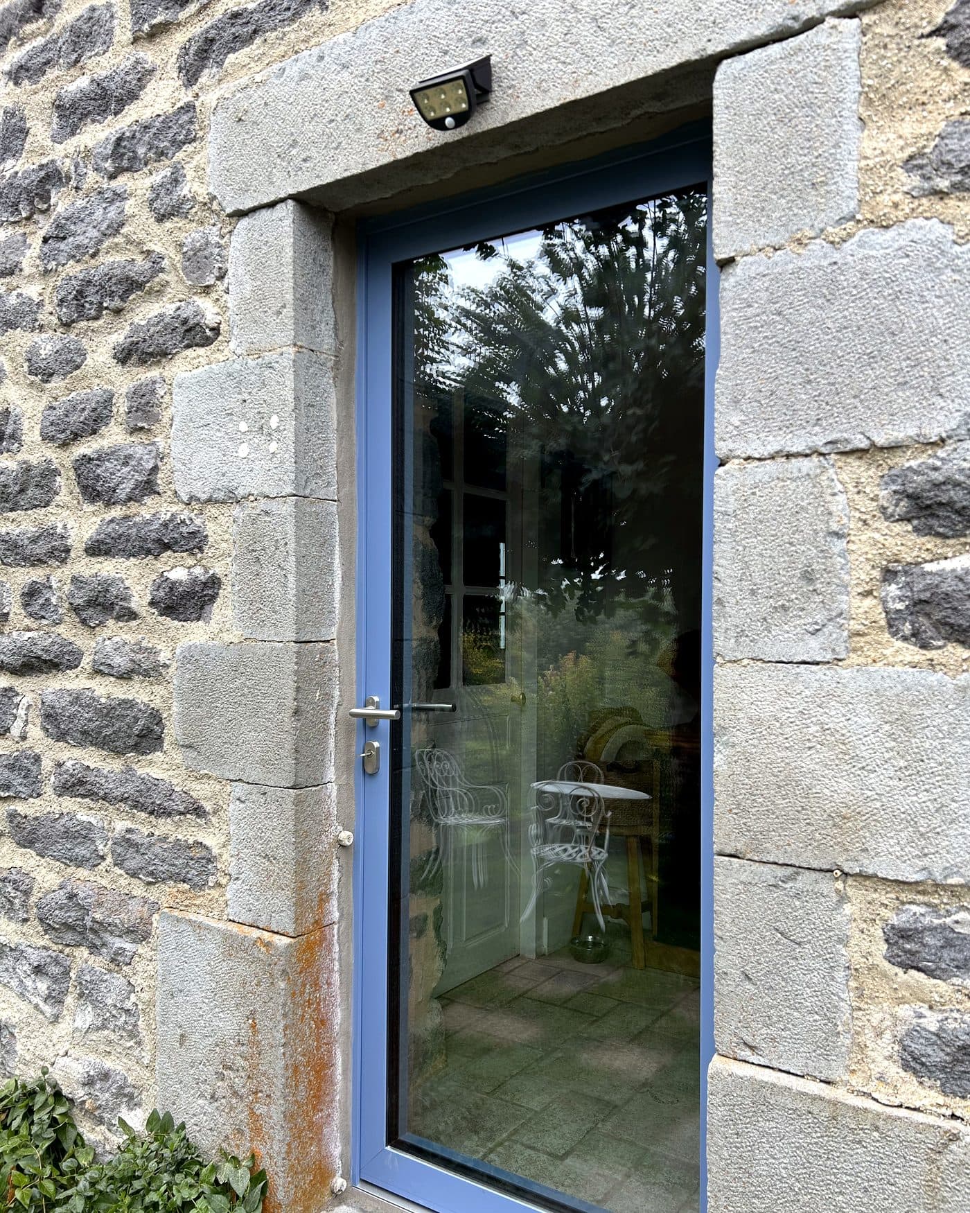Porte d'entrée bleue sur façade en pierre