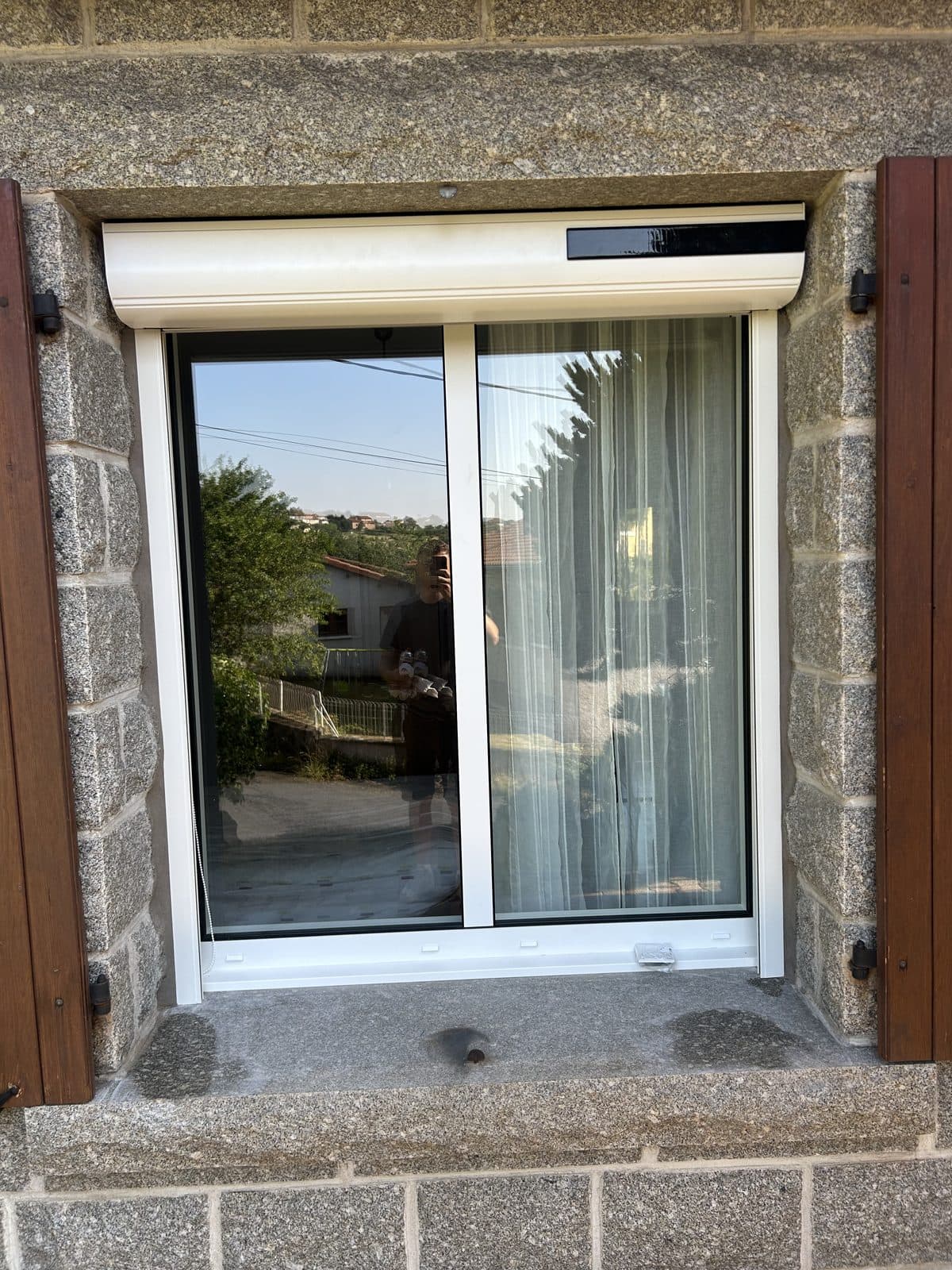 Volet roulant posé sur fenêtre coulissante, façade en pierre